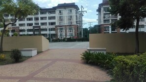 Un complejo residencial con varios edificios de apartamentos, un sendero pavimentado y áreas verdes.