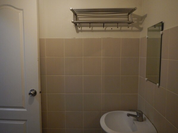 A bathroom with a sink, mirror, and towel rack.