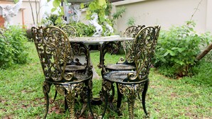 Ein Garten mit Tisch und verzierten Stühlen.