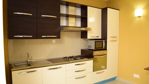 A kitchen with a sink, stove, microwave, and oven.