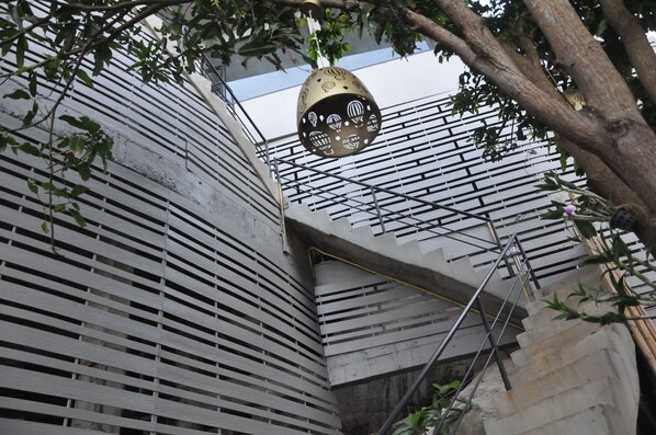 Un edificio moderno con fachada curva y un elemento decorativo colgante.
