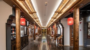 A corridor with wooden pillars, red lanterns, and a polished floor. - Grand Pacific Hotel Ningbo (Ningbo)