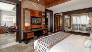 A modern hotel room with a large bed, a desk with a computer, a television, and a bathroom with a glass shower. - Grand Pacific Hotel Ningbo (Ningbo)