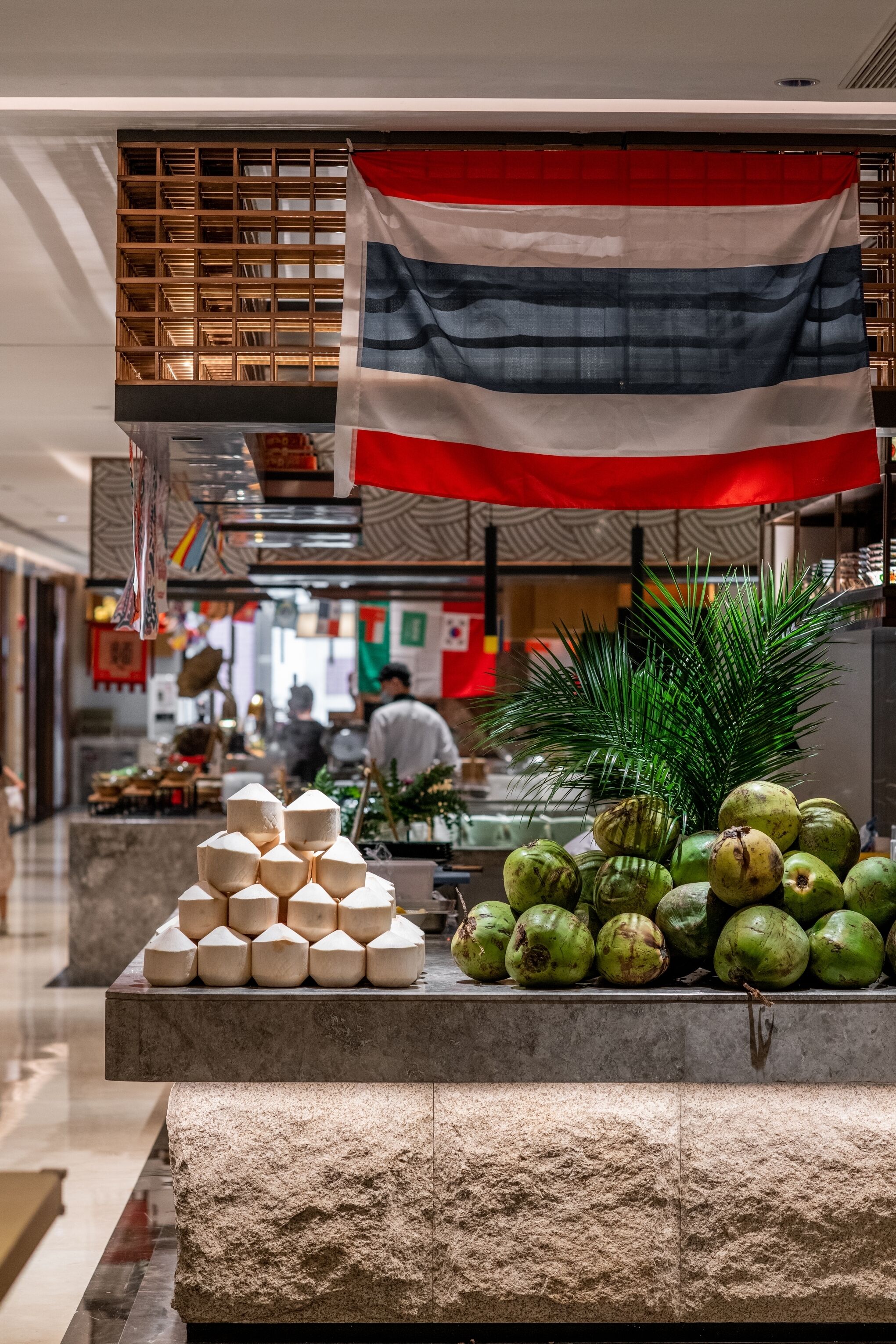 A display of coconuts and a flag in a shopping area.