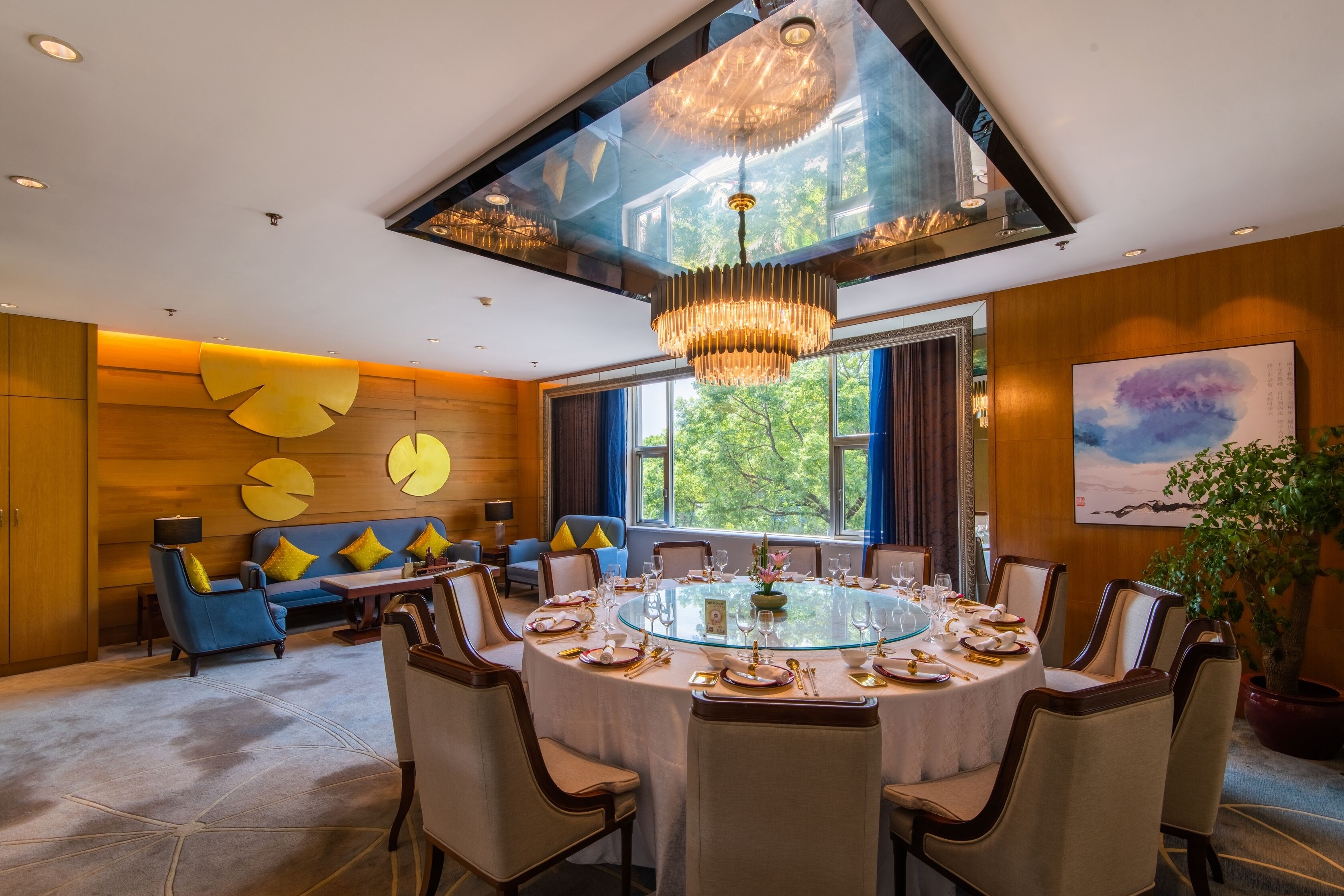 A dining area with a round table set for six, surrounded by chairs.
