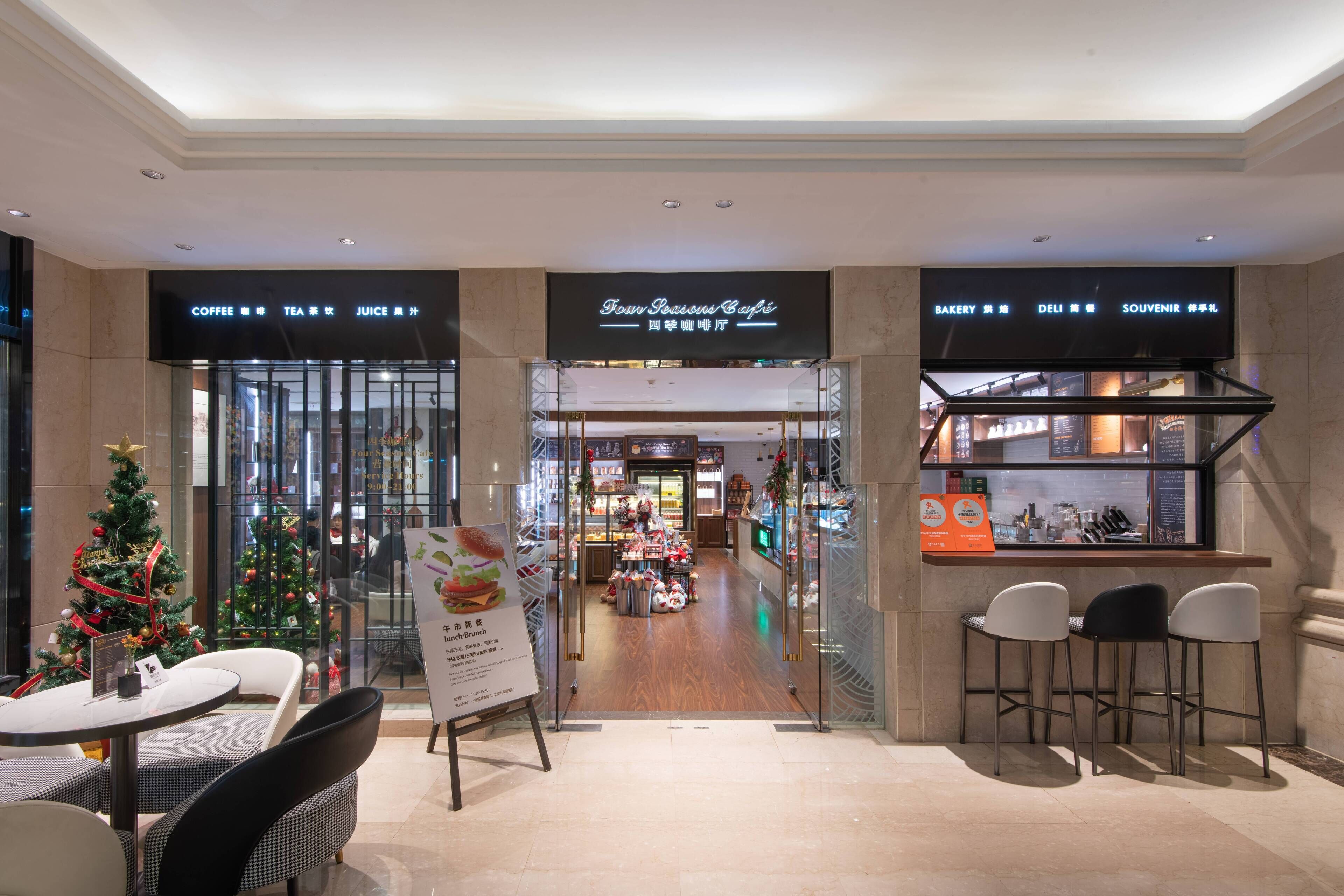 A modern cafe with a Christmas tree and a menu board.