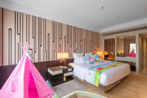 Una habitación de hotel con una cama, una mesita de noche, una lámpara, una tienda de campaña rosa y un espejo.