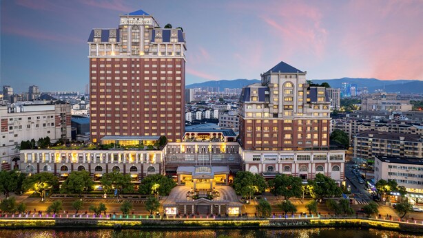 A hotel with a prominent red facade, a large central building, and a smaller attached structure. - Grand Pacific Hotel Ningbo (Ningbo)
