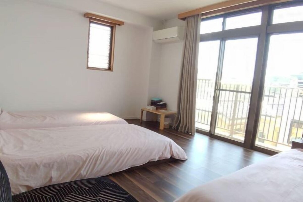 Een hotelkamer met twee bedden, een tafeltje en uitzicht op het balkon.