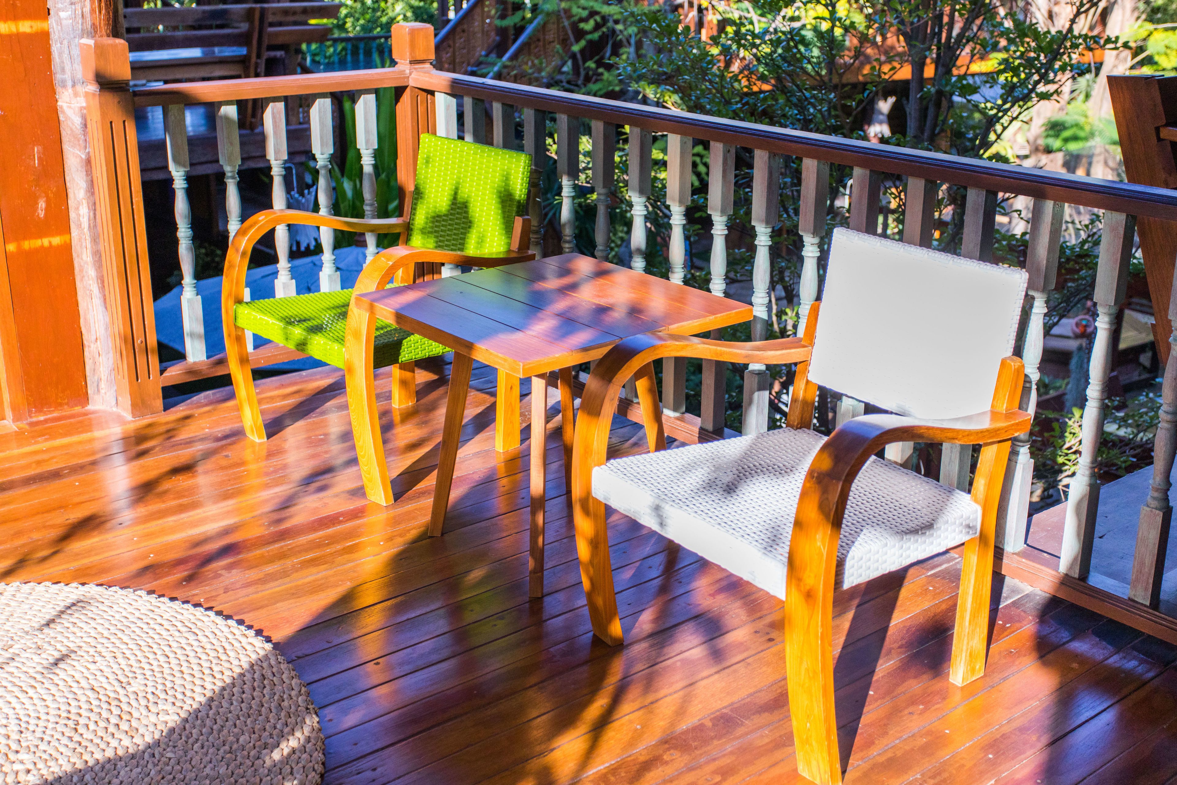 Una terraza de madera con una mesa y dos sillas.