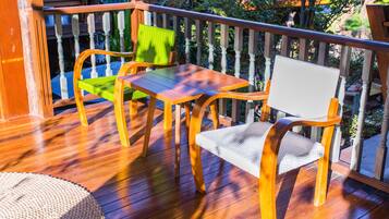 Una terraza de madera con una mesa y dos sillas.