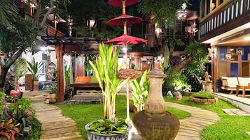 A well-lit outdoor area with a wooden bench, a large decorative vase, and a sign that reads "WELCOME".