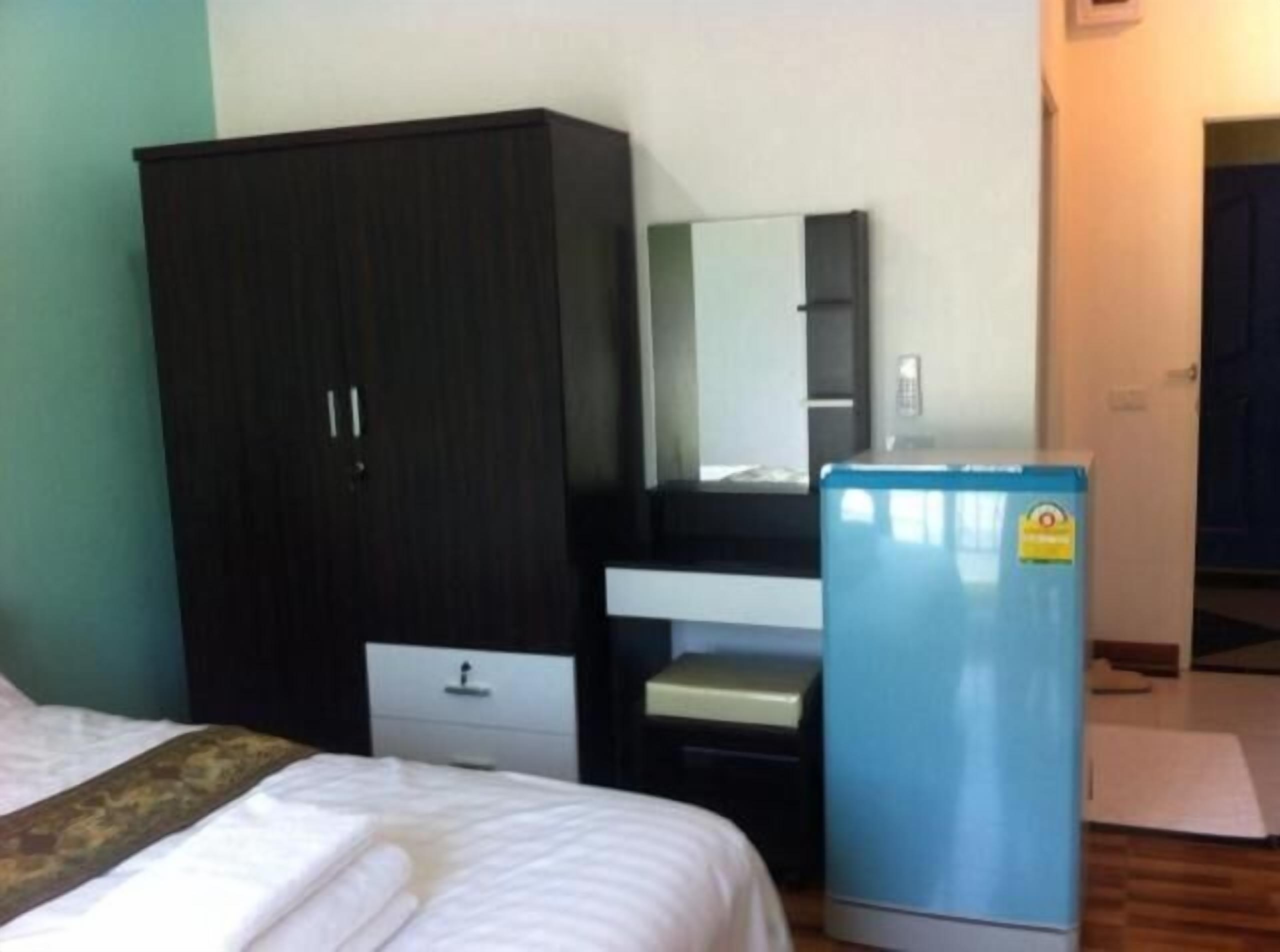 A bedroom with a bed, a wardrobe, a desk, and a blue refrigerator.