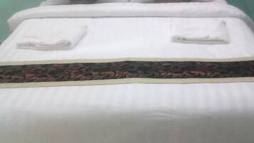 Una cama con cabecera, dos almohadas y una colcha estampada.