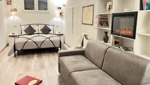 A bedroom with a bed, a sofa, a fireplace, and a bookshelf. - Il Tempio di Morfeo (Rome)