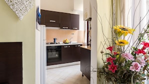 Cuina amb armaris foscos, fogó i rentaplat. Hi ha una decoració amb forma de cor a la paret i un ram de flors al taulell.