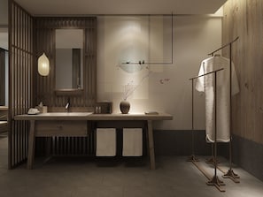 Un baño moderno con tocador de madera, un espejo grande, una lámpara colgante y un perchero para toallas.