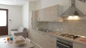 Una cocina moderna con una campana de acero inoxidable, un lavamanos doble y un horno empotrado.