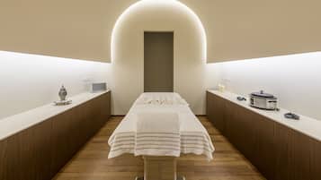 Stylish room with a central bed, semi-circular archway, and two side tables with lamps and amenities.