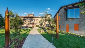 A stone building with a paved pathway leading to a gated entrance. - Borgo Cadonega Relais & SPA (Viano)