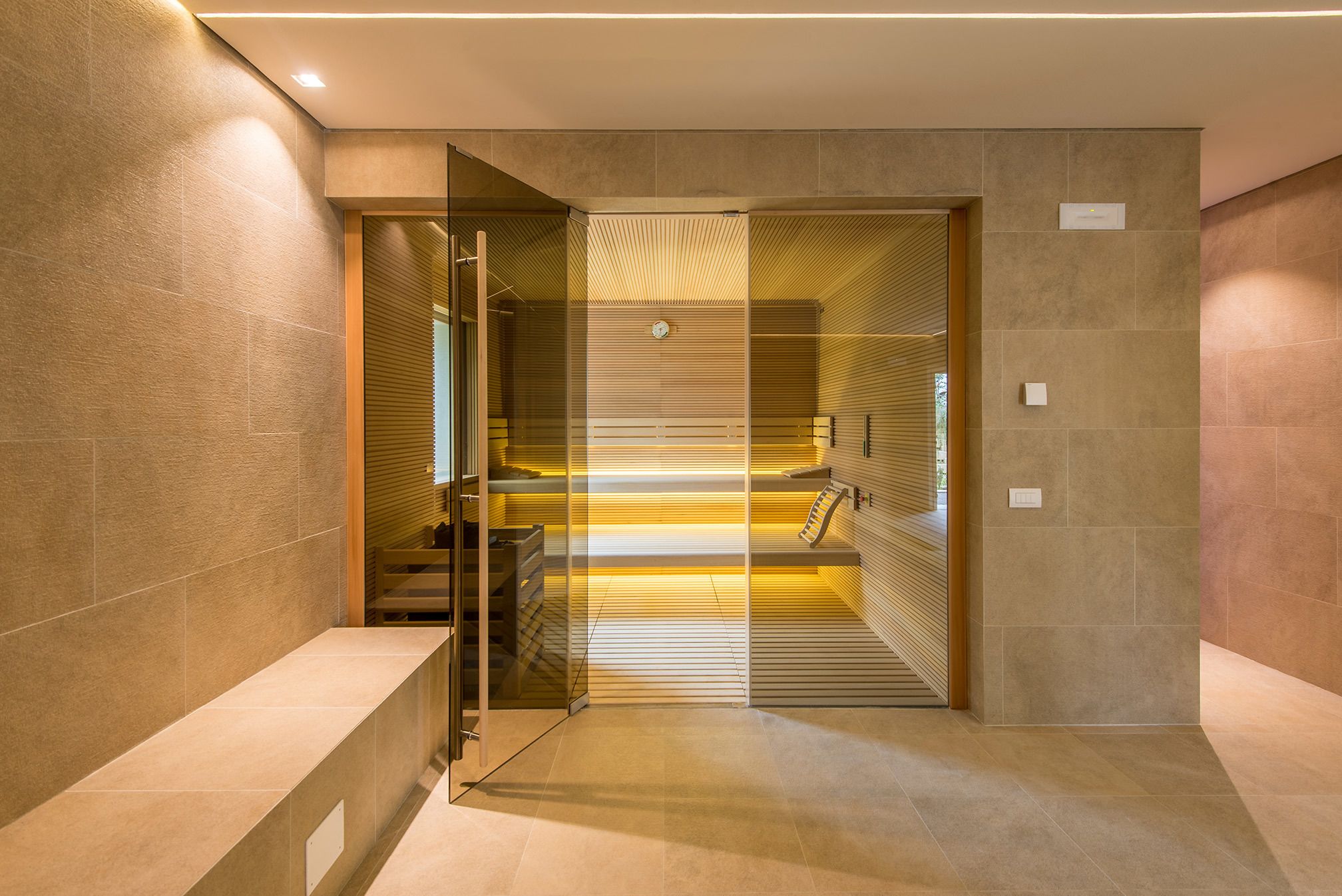 Un moderno vestíbulo de hotel con una puerta de cristal que da a una escalera.