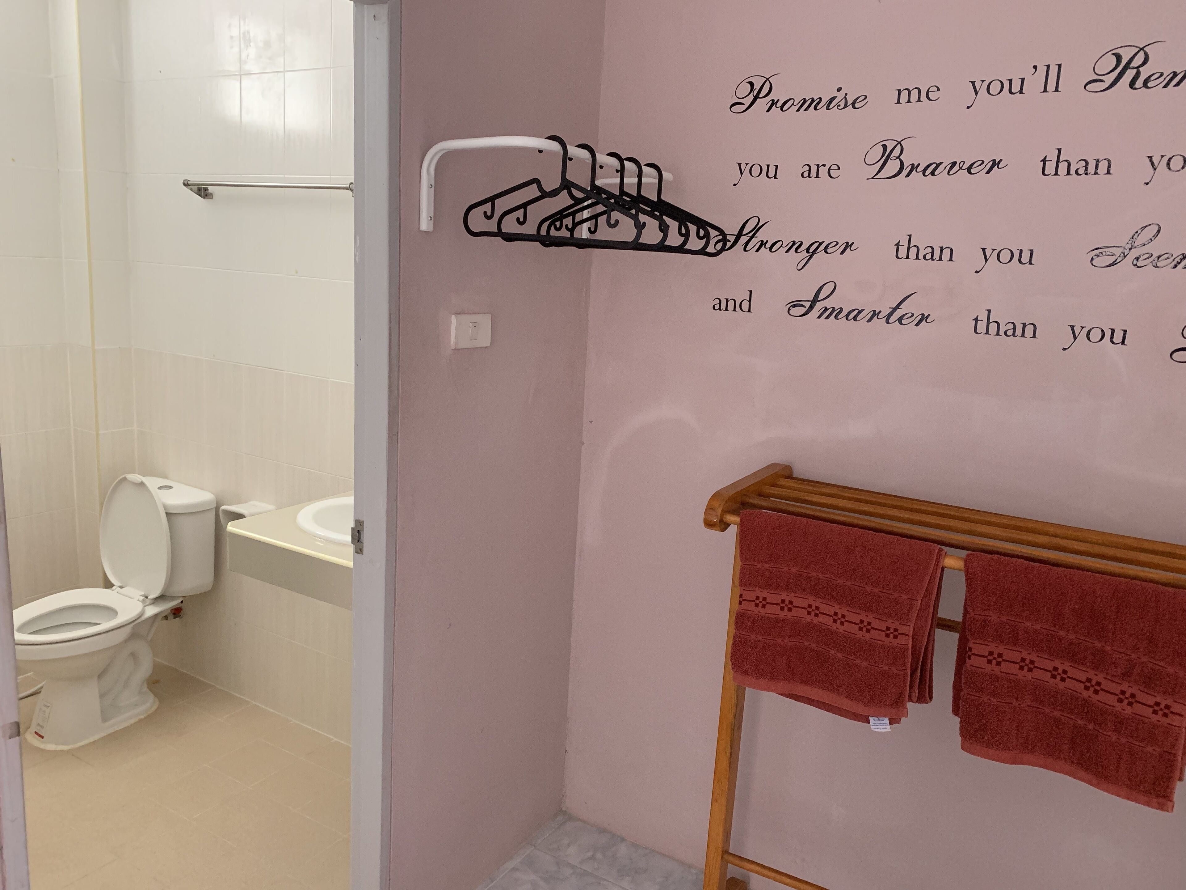 Ein Badezimmer mit Toilette, Waschbecken und Handtuchhalter mit Handtüchern.