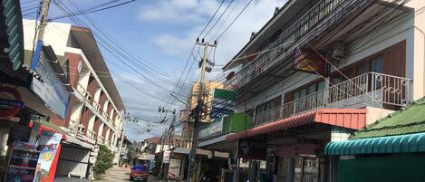 Vista de calle con edificios, líneas eléctricas y motocicletas estacionadas.