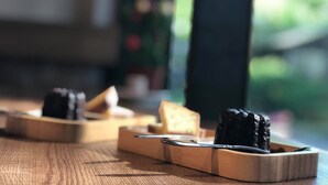 A wooden table with a few items on it, including a dark object and a lighter object. - FangShug B&B (Fenglin)
