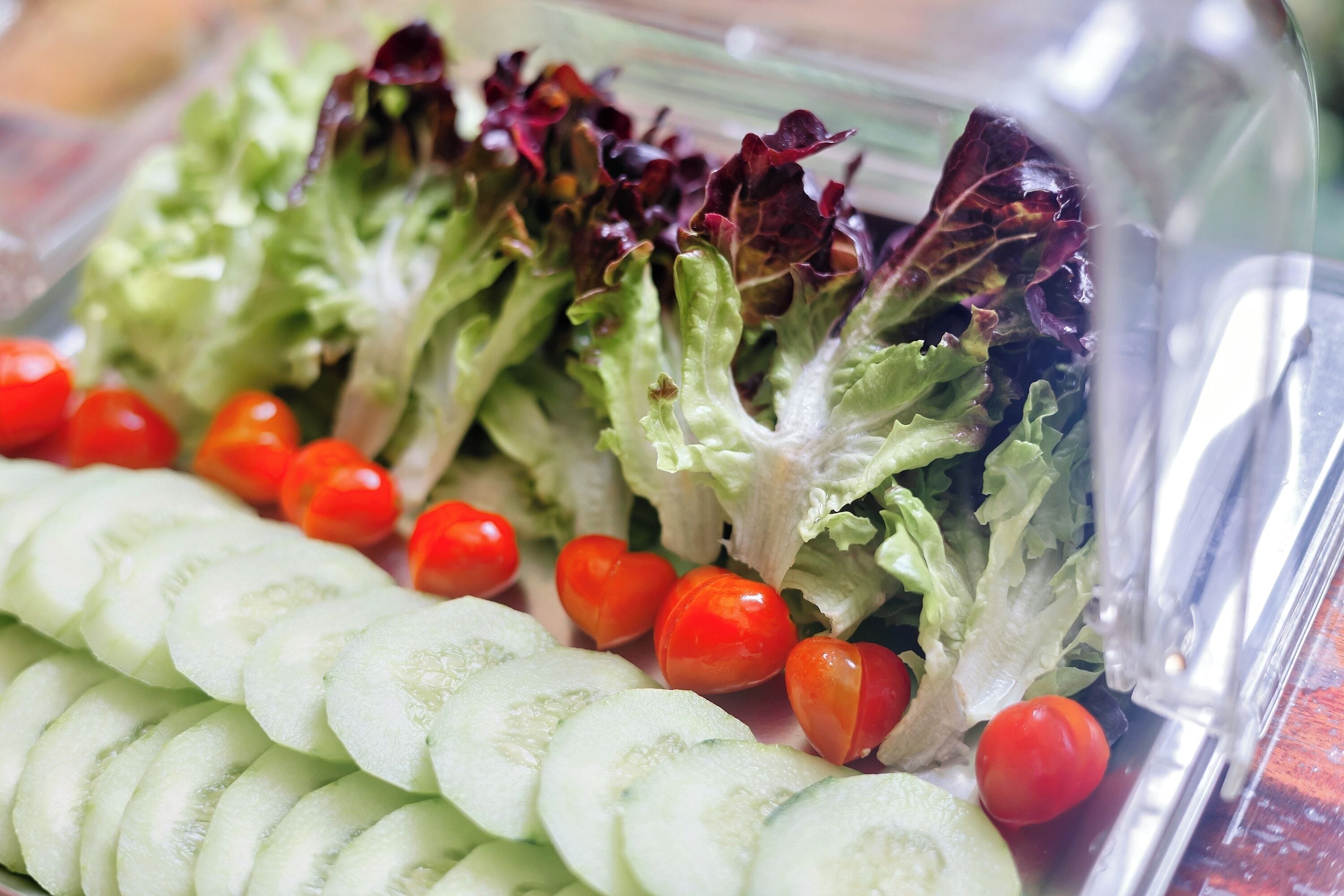 Une salade composée de laitue, de tomates et de rondelles de concombre.