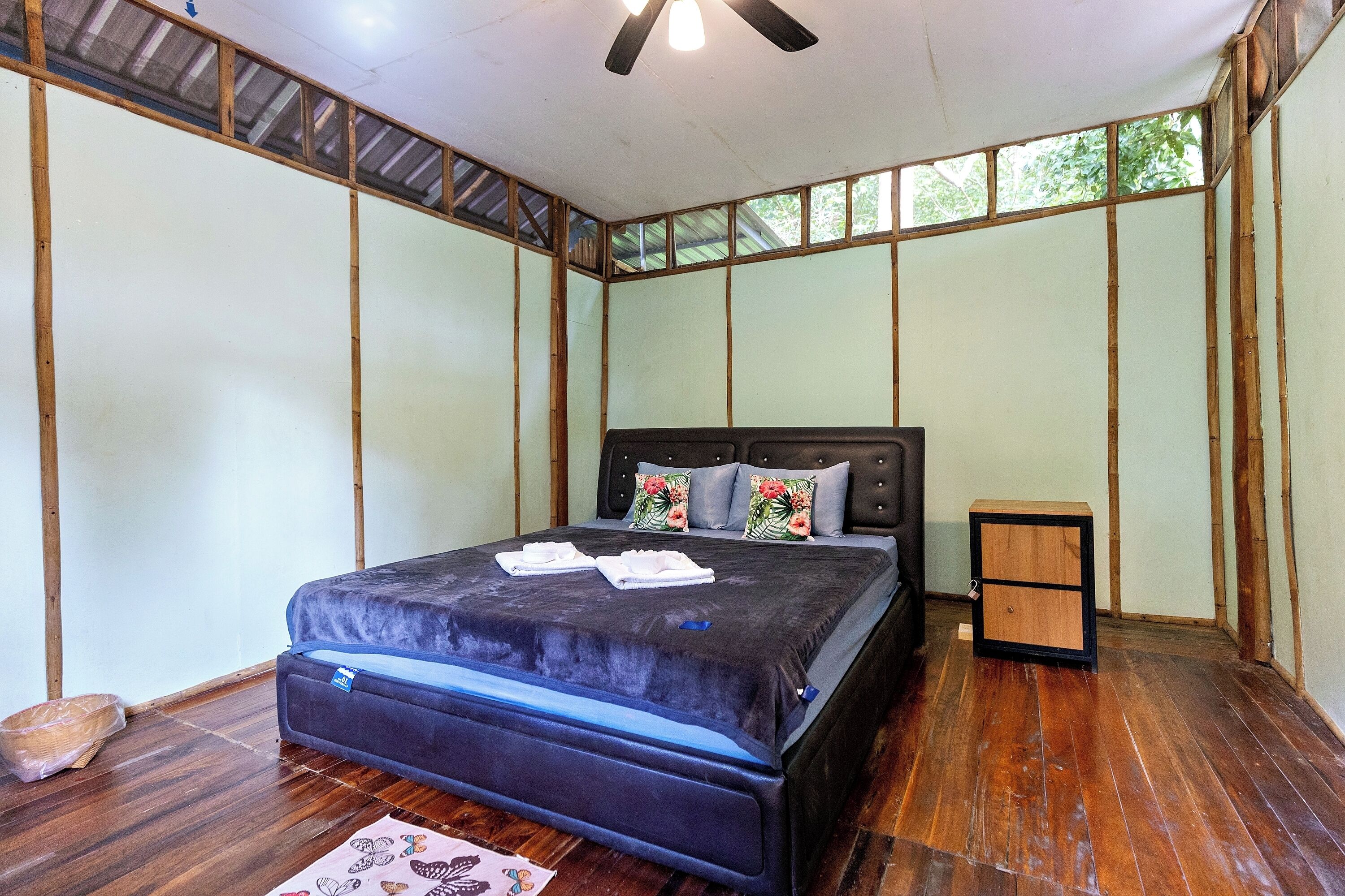 A bedroom with a bed, a nightstand, and a window.
