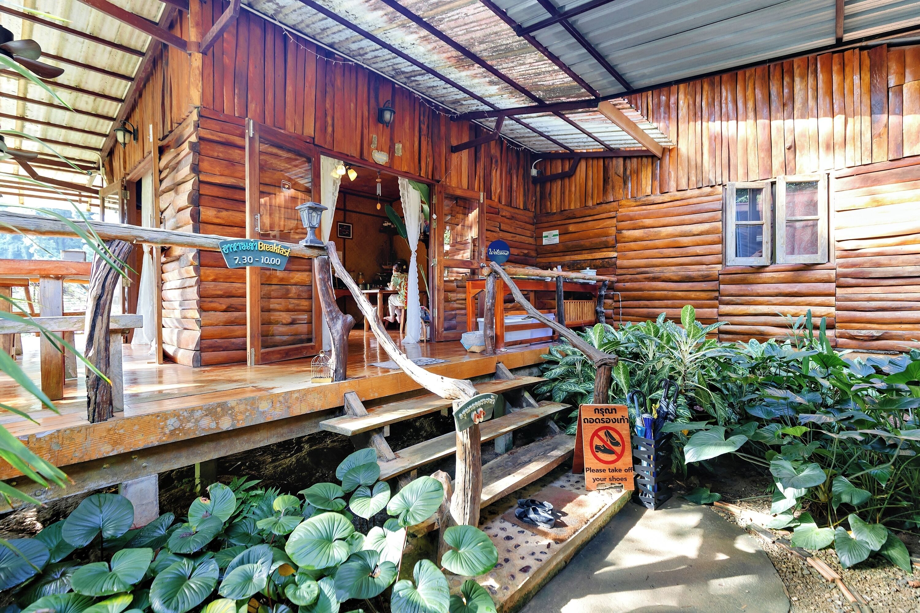 A rustic wooden cabin with a wooden deck and steps leading to the entrance.