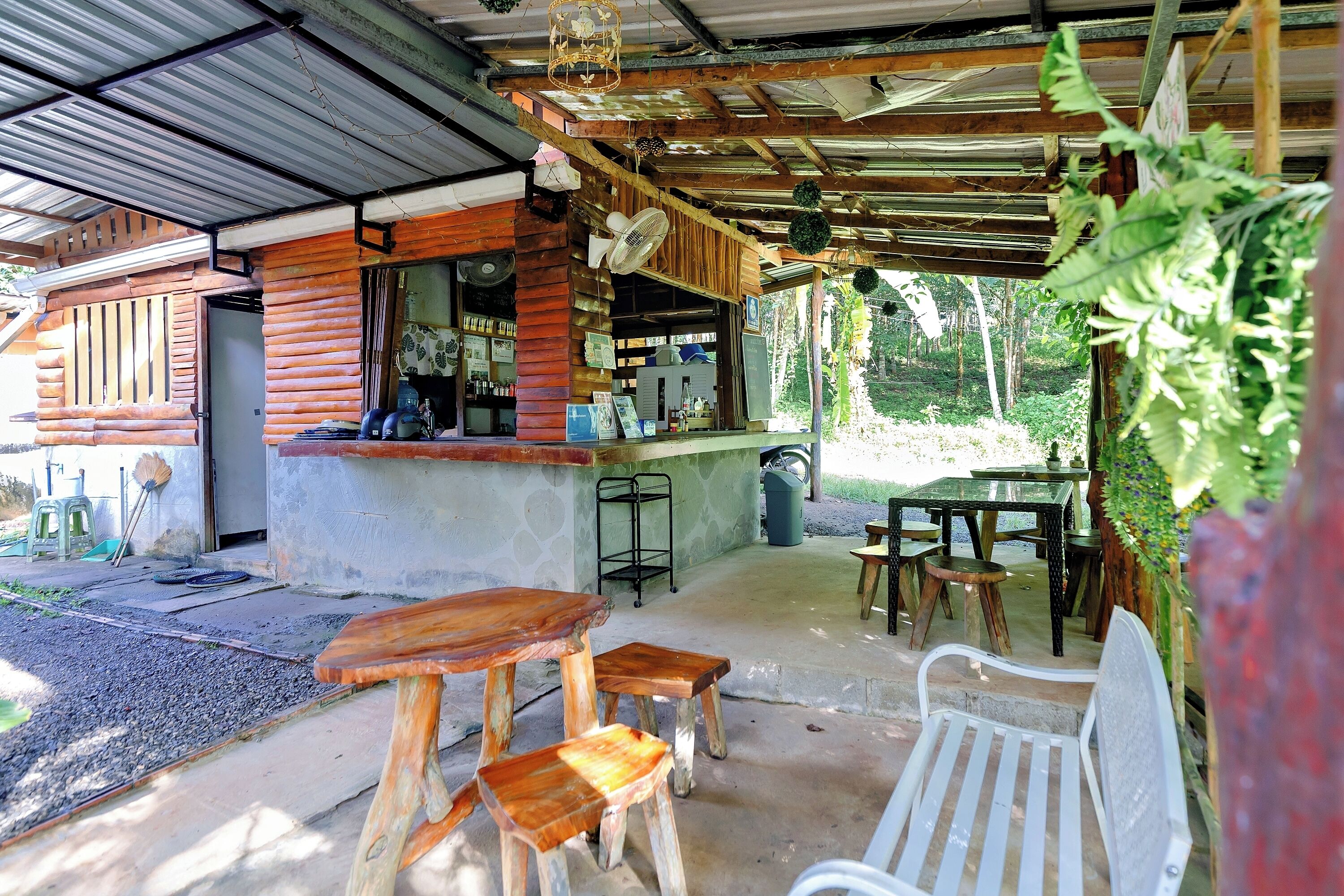 A rustic wooden structure with a bar area, outdoor seating, and a covered patio.