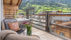 A wooden deck with a view of a mountainous landscape. - 24 by AvenidA - Mountain Hotel (Kaprun)