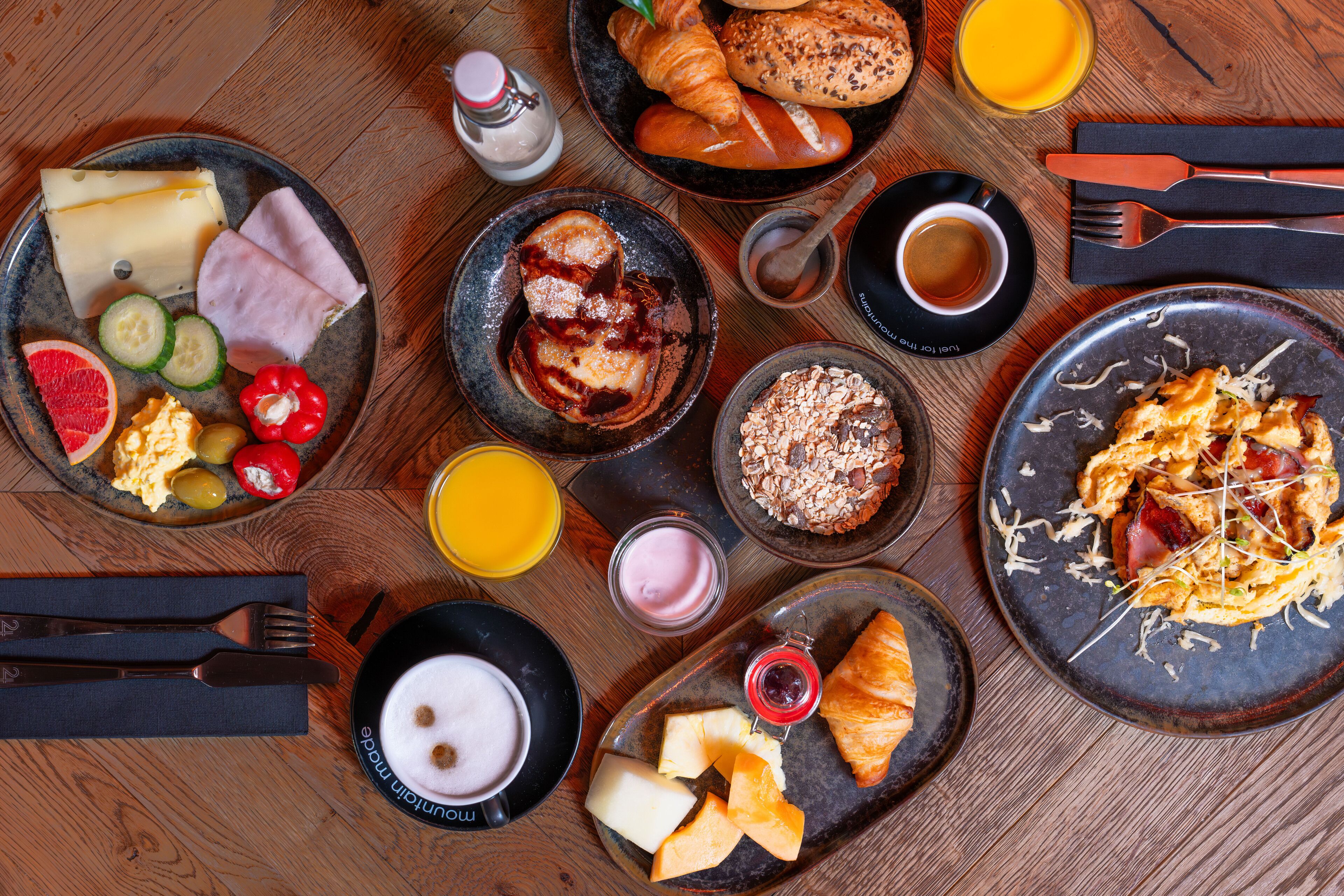 Un assortiment de plats et de boissons pour le petit-déjeuner, disposé sur une table en bois.