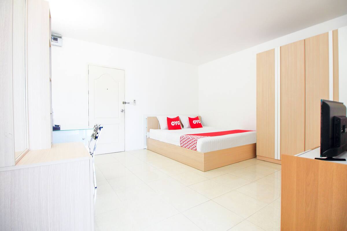 Ein modernes Hotelzimmer mit Bett, Fernseher und Holzmöbeln.
