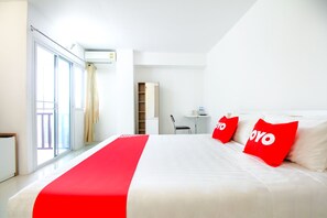 Una habitación de hotel con una cama grande, un escritorio y una silla.