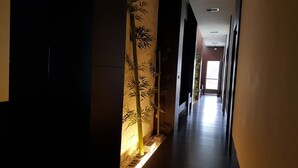 A corridor with a bamboo wall design, a tiled floor, and a door at the end. - Yang Homestay (Ruisui)