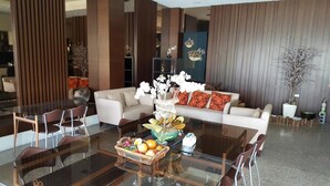 A modern living room with a glass coffee table, white sofa, and decorative pillows. - Yang Homestay (Ruisui)