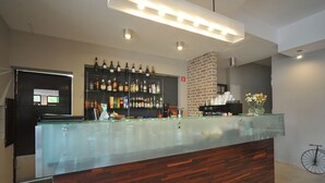A modern bar area with a glass counter, wooden paneling, and a variety of liquor bottles. - Vertigo Narie (Morag)
