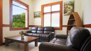 A living room with a leather sofa, a wooden coffee table, and a bookshelf. - Taomilou (Puli)