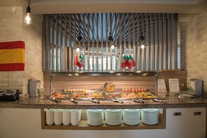 Un buffet proposant une variété de plats, un drapeau et une horloge.