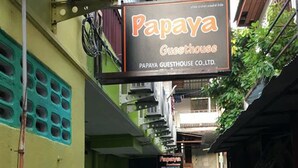 A narrow alleyway with a sign for 'Papaya Guesthouse' hanging above. - Lucky Guesthouse (Ko Phi Phi)