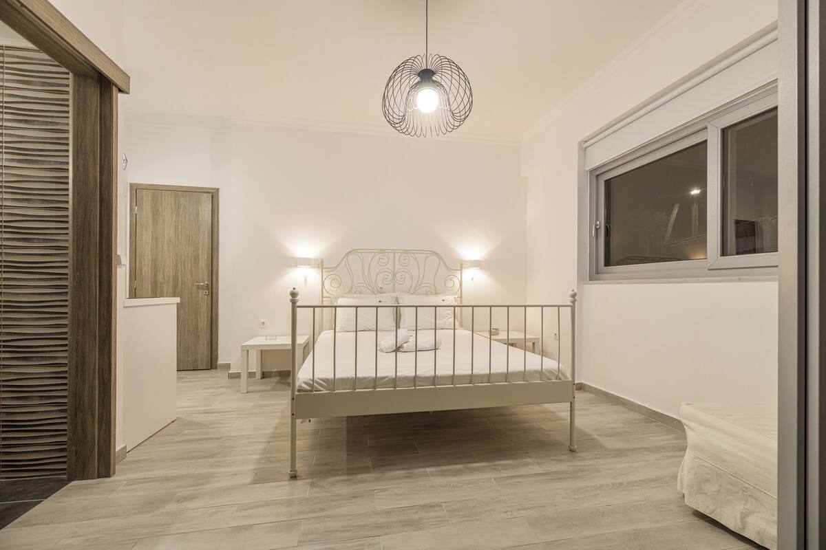 A bedroom with a bed, bedside tables, a wardrobe, and a window.