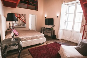 A bedroom with a bed, a TV, a desk, and a window. - Il Regio Boutique Hotel (Cagliari)