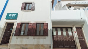 A building with a sign reading "WOT ERICIRA LODGE" and a window with wooden shutters.