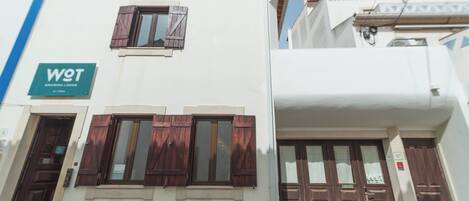Un edificio con un letrero que dice "WOT ERICIRA LODGE" y una ventana con contraventanas de madera.
