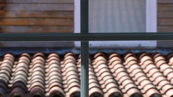 A close-up of a tiled roof with a window in the foreground.