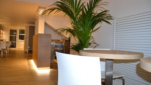 Una cocina moderna con suelo de madera, una isla central y una planta en maceta.