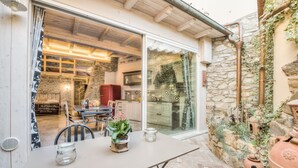 An outdoor dining area with a table, chairs, and potted plants. - Giglio Apartments by Mmega (Florence)