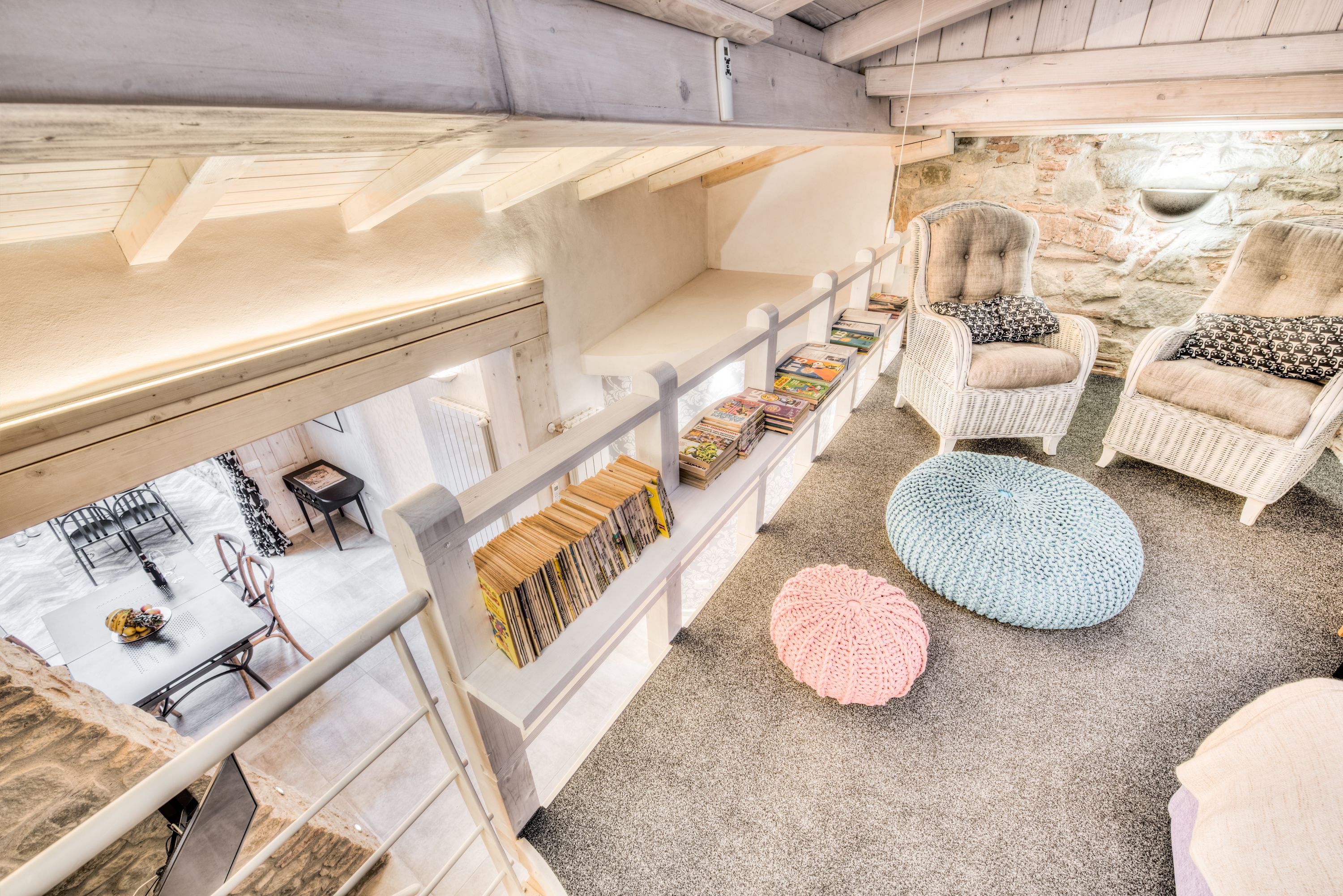 A cozy interior with wicker furniture, a dining area, and a bookshelf.